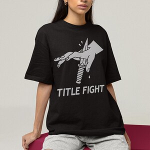 White sweatshirt worn by a model, front print placement with title fight on the main chest area.