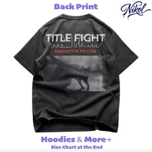 White unisex t-shirt mockup, back view on black background with Title Fight printed on the back.