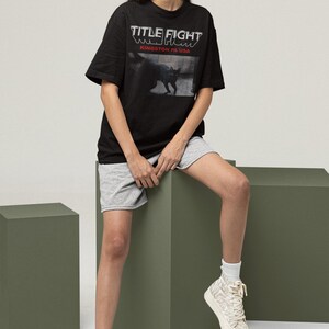 Model wearing a white long-sleeve t-shirt, front print placement featuring Title Fight.