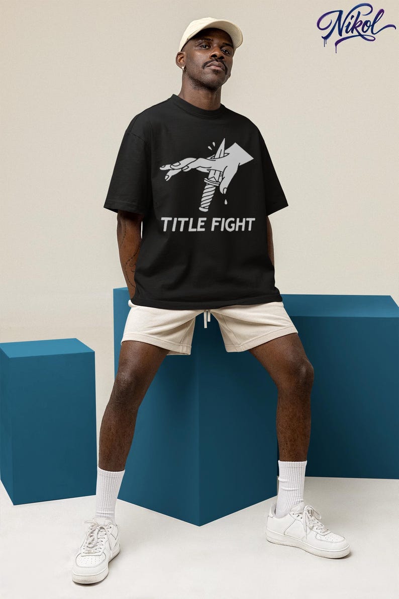 Flat lay white tank top in a beach-style scene, front print showcasing title fight on the chest area.