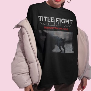 Front print lifestyle mockup of a white oversized t-shirt, Title Fight centered on the chest area.
