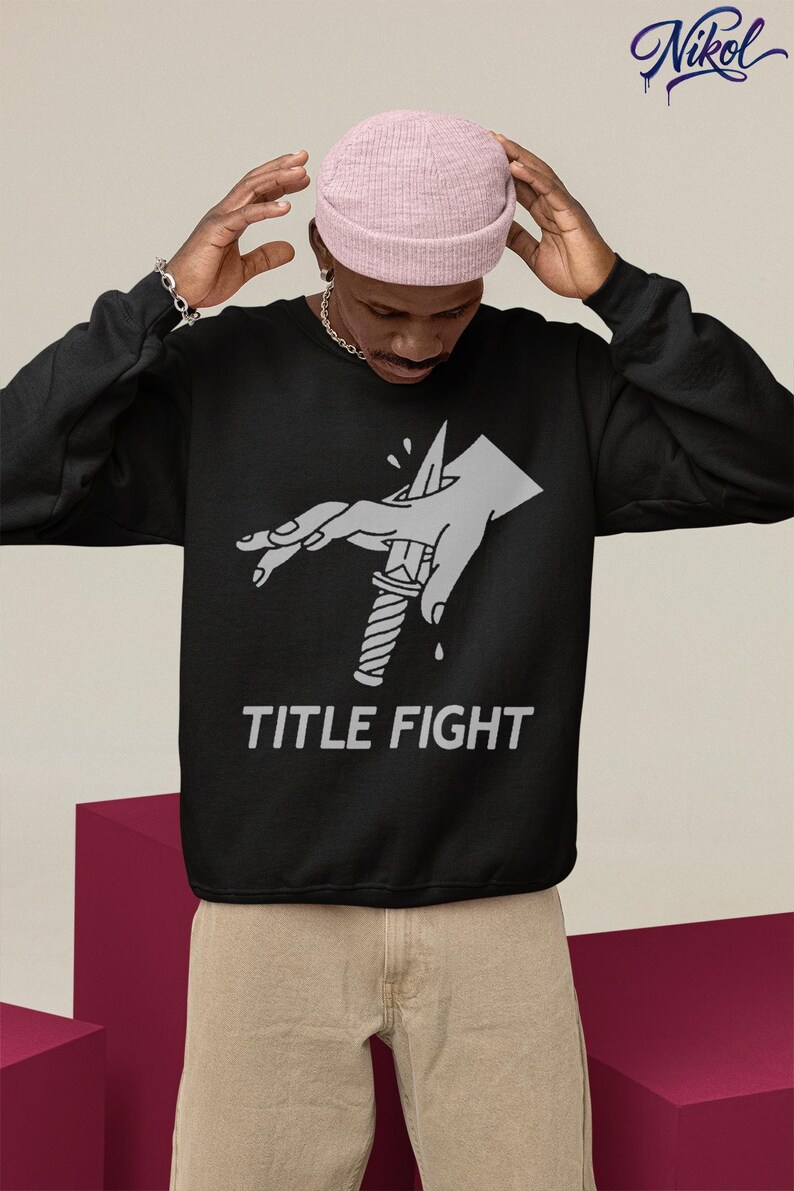 Indoor lifestyle shot of a white hooded sweatshirt from behind, featuring title fight as the back print.
