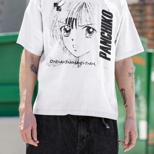 Close-up outdoor view of a white t-shirt, front design area showing panchiko deathmetal album.