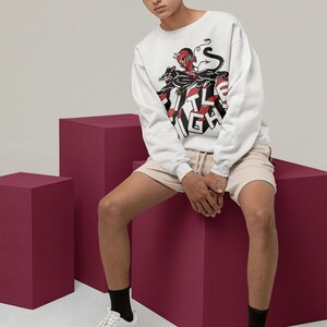 Lifestyle photo of a model wearing a white long-sleeve shirt with title fight printed on the front.