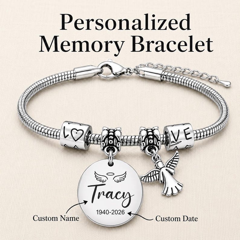 Peut inclure: Un bracelet en cha&icirc;ne serpent argent&eacute;e avec fermoir mousqueton, deux perles cylindriques grav&eacute;es LOVE et un c&oelig;ur, deux perles intercalaires, un pendentif rond avec des ailes d'ange et le nom Tracy 1940-2026, et une breloque ange.