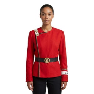 May include: A vibrant red jacket featuring a structured collarless neckline, a black belt with a prominent gold circular emblem, and a white shoulder strap with gold detailing. The sleeves include white cuffs with gold accents and horizontal stitching.
