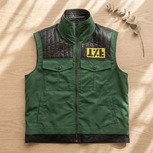 May include: Green vest with black quilted shoulders and collar. Features two front pockets with button closures and a black leather trim at the bottom. A yellow patch with the letters "I.Z.E." is on the chest.