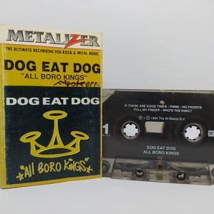 May include: A Dog Eat Dog "All Boro Kings" cassette tape and case. The case is yellow and black, with the band's name and album title. The cassette tape is clear with black text and song titles.