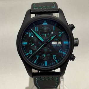 May include: Black wristwatch with a black face and strap. Teal accents highlight the hands, numerals, and markers on the watch face. The watch displays "IWC SCHAFFHAUSEN" and the date "THU 19".