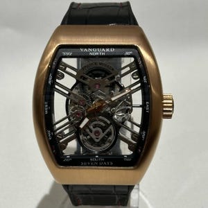Puede incluir: Un reloj Franck Muller Vanguard North en oro rosa con una correa de cuero negro. La esfera del reloj tiene un diseño de esqueleto, que revela el intrincado funcionamiento interno. El reloj muestra el texto "VANGUARD NORTH" y "SEVEN DAYS".
