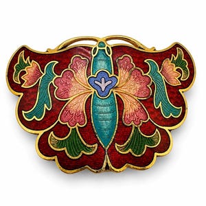 May include: A gold-toned metal brooch shaped like a stylized butterfly, featuring intricate cloisonné enamel work in deep red, turquoise, pink, and green. The central body is turquoise with a small blue and lavender floral detail at the top.