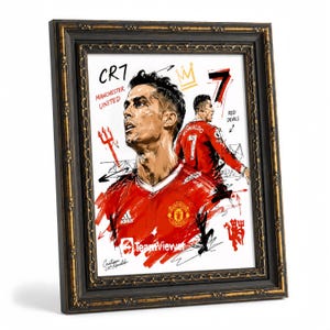 May include: Framed artwork featuring a portrait of Cristiano Ronaldo in a red Manchester United jersey. The artwork includes the text "CR7 Manchester United" and a crown graphic. The frame is black with gold trim.