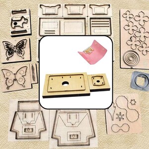 Puede incluir: Una colección de troqueles de madera para trabajar el cuero, con diversas formas que incluyen mariposas, flores y patrones geométricos. Un pequeño llavero de cuero rosa se muestra en el centro junto a dos troqueles rectangulares.