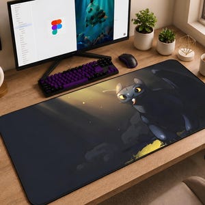 May include: A rectangular desk mat featuring a large, black, dragon-like creature with glowing yellow eyes and a small white tooth visible. The mat has a dark, atmospheric background with soft lighting and is positioned on a wooden desk surface.
