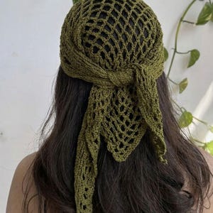 May include: Olive green crochet head covering with a net-like design. The head wrap features a knotted tie at the back and long, flowing ends. The handmade headwear is a stylish accessory.