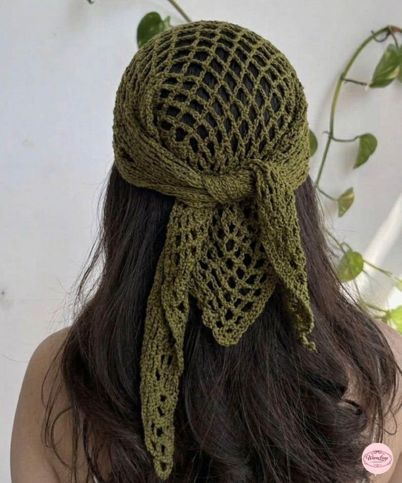 May include: Olive green crochet head covering with a net-like design. The head wrap features a knotted tie at the back and long, flowing ends. The handmade headwear is a stylish accessory.