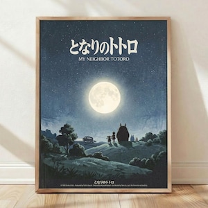 May include: Framed poster print leaning against white wall on wooden floor. Artwork shows nighttime scene with large full moon, starry blue sky, silhouettes of Totoro and children standing near Catbus on rolling hills with trees. Japanese text at top reads "My Neighbor Totoro" in white lettering. Natural wood frame, soft lighting with shadows cast on textured white wall.