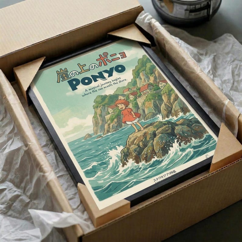May include: Framed Ponyo poster print in black frame, packed in cardboard shipping box with protective white tissue paper. The vintage-style artwork shows the red-haired character standing on rocky cliffs by turbulent ocean waves, with Japanese text and English subtitle. Coastal village visible on green hillside in background. Muted teal and green color palette with cream border.