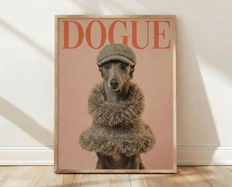 May include: Framed poster print featuring a whippet dog wearing a herringbone newsboy cap and layered fuzzy brown scarves against a warm peach background, with "DOGUE" text in orange letters at top, displayed on light wood flooring against white walls with natural lighting creating soft shadows