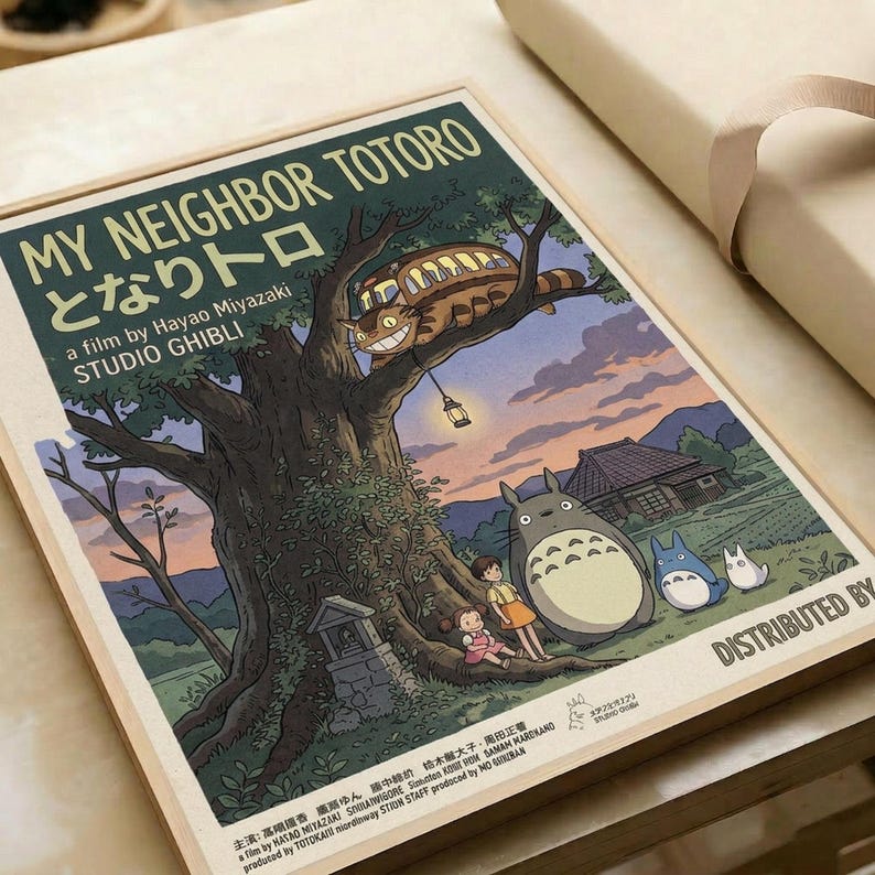May include: Vintage-style movie poster print displayed on white paper or parchment. Features iconic forest scene with large camphor tree, cartoon cat bus perched in branches, and beloved forest spirit character standing below with two children. Artwork shows twilight sky with purple and orange hues, traditional Japanese house in background. Print has aged, cream-colored borders with text at top and bottom in classic movie poster layout.