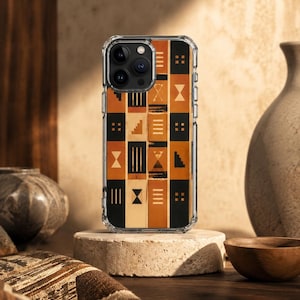 Peut inclure: Une coque de téléphone transparente de protection arborant un motif en grille rectangulaire avec des panneaux verticaux alternant noir, beige et orange brûlé. Le design inclut des symboles géométriques comme des escaliers et des lignes.