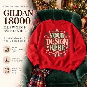 Pode incluir: Uma camisola vermelha de gola redonda com um gráfico central com o texto "YOUR DESIGN HERE" em creme e verde, rodeado por uma coroa decorativa de folhas, corações e um laço. O texto "LUNETTA STUDIO ART GILDAN 18000 CREWNECK SWEATSHIRT" é visível.