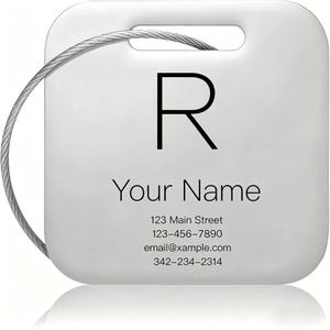 Può includere: Un'etichetta per bagagli quadrata bianca con angoli arrotondati e un cavo metallico argentato. L'etichetta presenta una grande lettera R nera, il testo Your Name e informazioni di contatto segnaposto: 123 Main Street, 123-456-7890, email@xample.com e 342-234-2314.