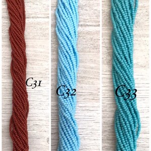 May include: Three strands of seed beads, one brown, one light blue, and one turquoise.