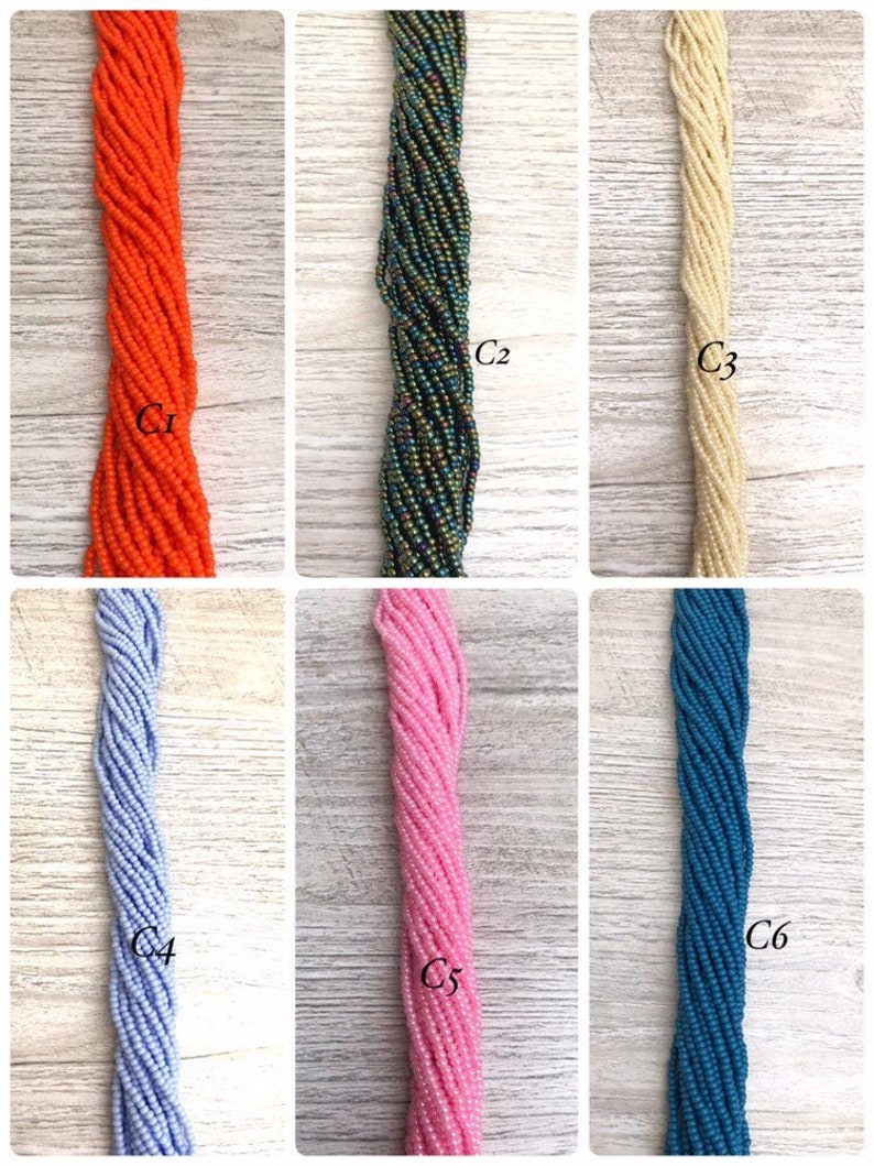 May include: Six strands of seed beads in various colours, including orange, green, cream, light blue, pink, and teal. The beads are arranged vertically in a row, with each strand labelled with a number.
