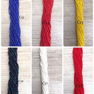 May include: Assortment of seed beads in various colours, including blue, red, yellow, white, and black. The beads are arranged in rows and labelled with numbers C13 through C18.