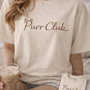 以下が含まれることがあります： 手書き風の「Welcome」の文字が入った、白く風化した木製の看板。素朴な外観で、装飾的な花の要素があります。背景は家のぼやけた画像です。