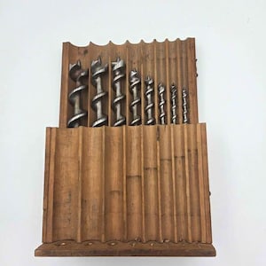 May include: A white ceramic mug with a black handle and the text "But First, Coffee" in a bold, black font. The mug is sitting on a wooden surface. The mug is approximately 4 inches tall.