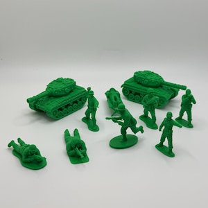 Peut inclure: Ensemble de jouets en plastique vert représentant des soldats et des chars. L'ensemble comprend deux chars et plusieurs soldats dans diverses poses, debout, à genoux et couchés. Les jouets sont d'un vert uni.