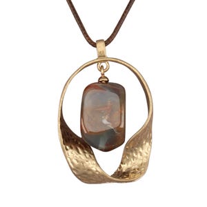 May include: A pendant necklace featuring a polished, multi-colored stone in shades of brown, gray, and white, suspended within a textured, gold-toned metal frame with a twisted, open-loop design, attached to a thin, dark brown cord.