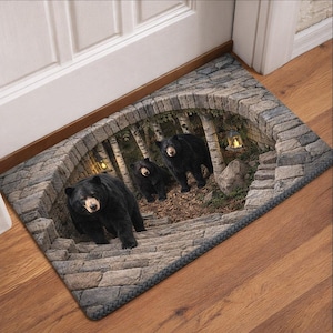 Pode incluir: Tapete retangular com uma imagem 3D de três ursos negros descendo degraus de pedra para uma floresta. Os ursos têm olhos e narizes castanhos. O tapete tem um design de arco de pedra com um fundo de floresta e duas lanternas.