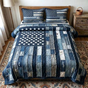 May include: A denim quilt and two matching pillow shams arranged on a wooden bed frame. The quilt and pillow shams feature a patchwork design resembling the American flag, with white stars on a blue field and blue and white stripes.