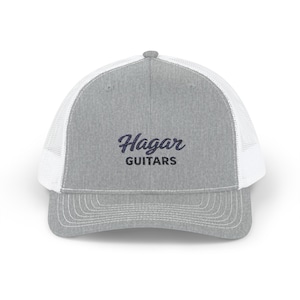 Puede incluir: Gorra de camionero gris con la parte trasera de malla blanca y una visera curva. La gorra presenta el texto "Hagar GUITARS" en una escritura azul oscuro en la parte delantera.