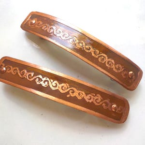Small etched copper hair barrettes. Pair of hand etched metal hair barrettes with reversing curls pattern on antiqued copper.