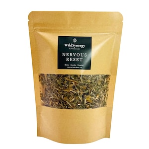 May include: A brown paper bag with a clear window displaying a green herbal blend. The bag has a black label with white text that reads "WildSynergy Apothecary NERVOUS RESET Relax - Soothe - Unwind". The bag is sealed and ready for use.