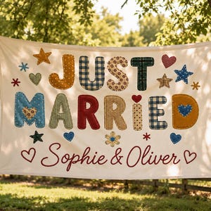 Puede incluir: Una pancarta de tela blanca con el texto JUST MARRIED en letras coloridas, estampadas y estilo acolchado. Debajo, los nombres Sophie & Oliver están impresos en letra roja, rodeados de varios iconos de tela con estrellas, corazones y flores.