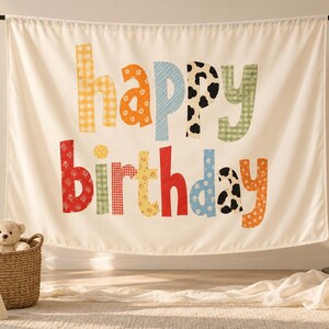 Może przedstawiać: Kremowe tło z tkaniny z napisem "happy birthday" wykonanym z dużych, wielokolorowych liter o r&oacute;żnych wzorach. Litery prezentują rozmaite nadruki, w tym kratkę vichy, motywy kwiatowe oraz łaty krowie w odcieniach czerwieni, pomarańczu, błękitu i zieleni.