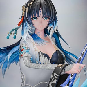Può includere: Una dettagliata statuetta in stile anime che raffigura un personaggio con lunghi capelli neri con riflessi blu, occhi azzurri luminosi e un abito bianco e blu con piume. La figura presenta intricati motivi argentati sulle maniche e tiene un arco blu.