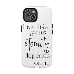 Könnte beinhalten: Weißes Smartphone-Case mit schwarzem Kameramodul und dem Zitat "Live like your eternity depends on it" in schwarzer Schrift. Das Case ist für ein Smartphone konzipiert und hat eine glatte, glänzende Oberfläche.