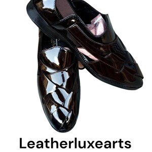 May include: A pair of dark brown, high-gloss patent loafers featuring a woven-style upper design, elastic side panels, and a sleek silhouette. The text Leatherluxearts is displayed below the shoes, which have a polished finish and dark soles.