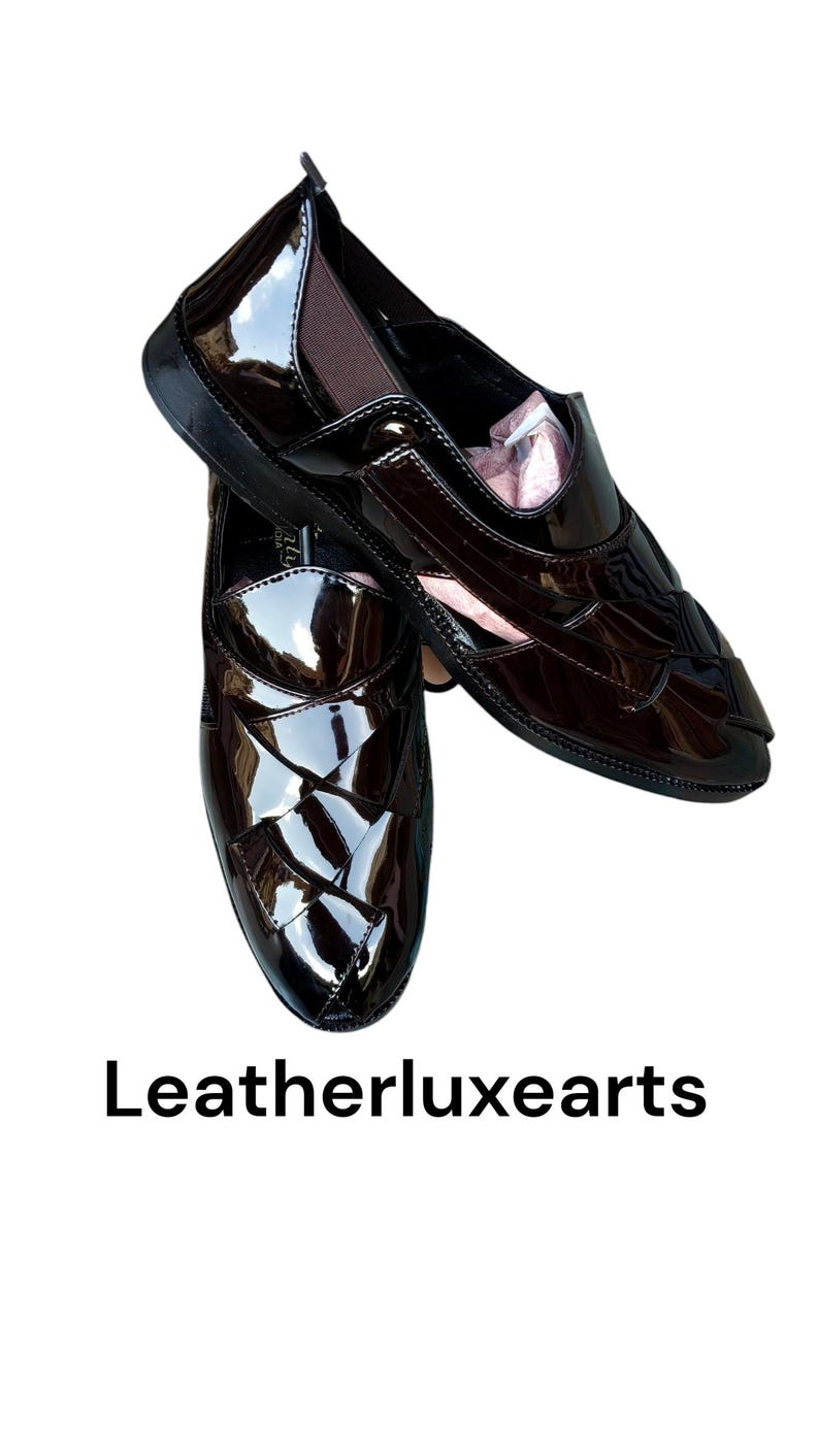 May include: A pair of dark brown, high-gloss patent loafers featuring a woven-style upper design, elastic side panels, and a sleek silhouette. The text Leatherluxearts is displayed below the shoes, which have a polished finish and dark soles.