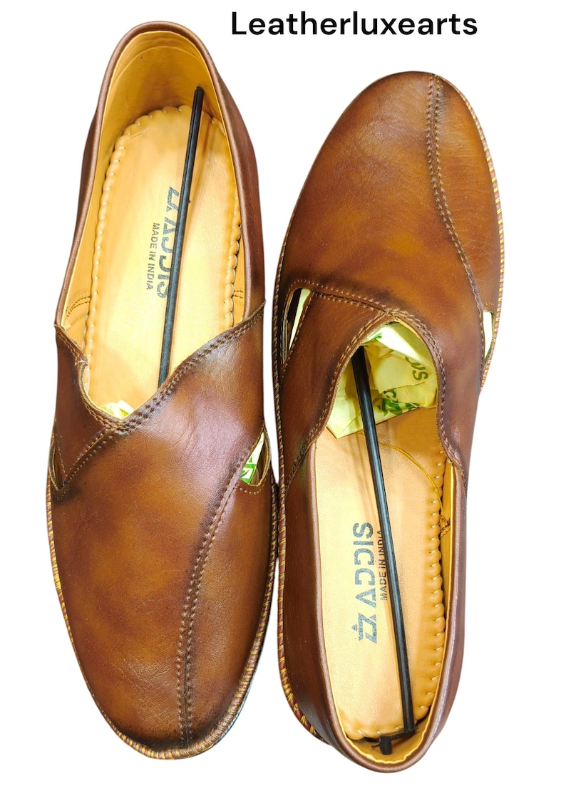 Puede incluir: Un par de zapatos de cuero marr&oacute;n con dise&ntilde;o sin cordones. Los zapatos tienen un patr&oacute;n cosido y un corte lateral. La marca "SICCIS" es visible en la plantilla. El texto "Leatherluxearts" est&aacute; en la parte superior.