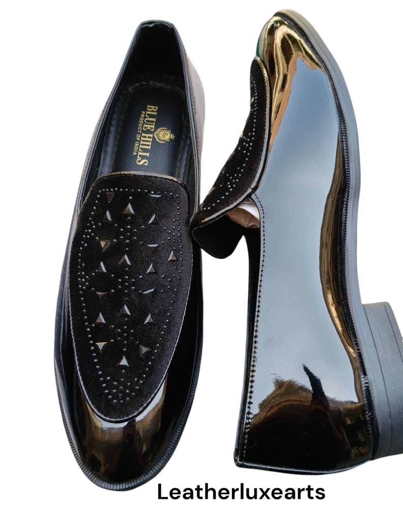 May include: A pair of black patent leather loafers with a velvet vamp featuring triangle cutouts. The shoes have a glossy finish and a low heel. The brand "BLUE HILLS PRODUCT OF INDIA" is visible inside the shoe. The text "Leatherluxearts" is at the bottom.