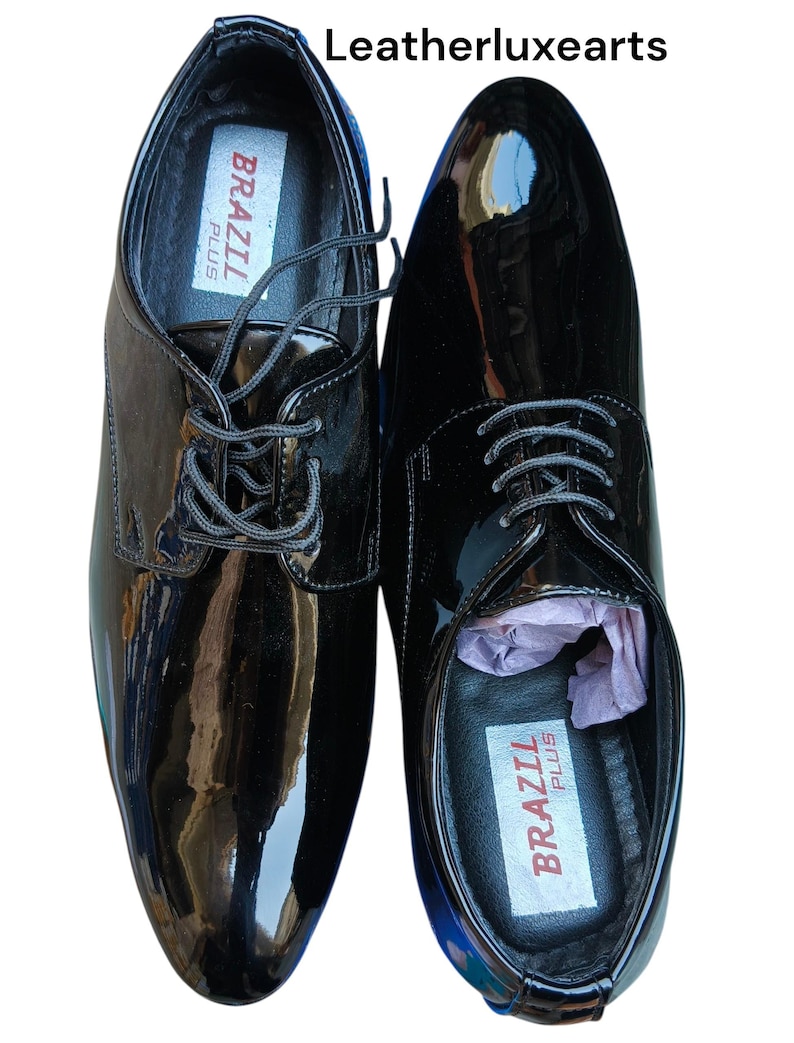 May include: Pair of glossy black dress shoes with laces. The shoes have a shiny patent leather finish and the brand name "BRAZIL PLUS" is visible inside. The text "Leatherluxearts" is at the top.
