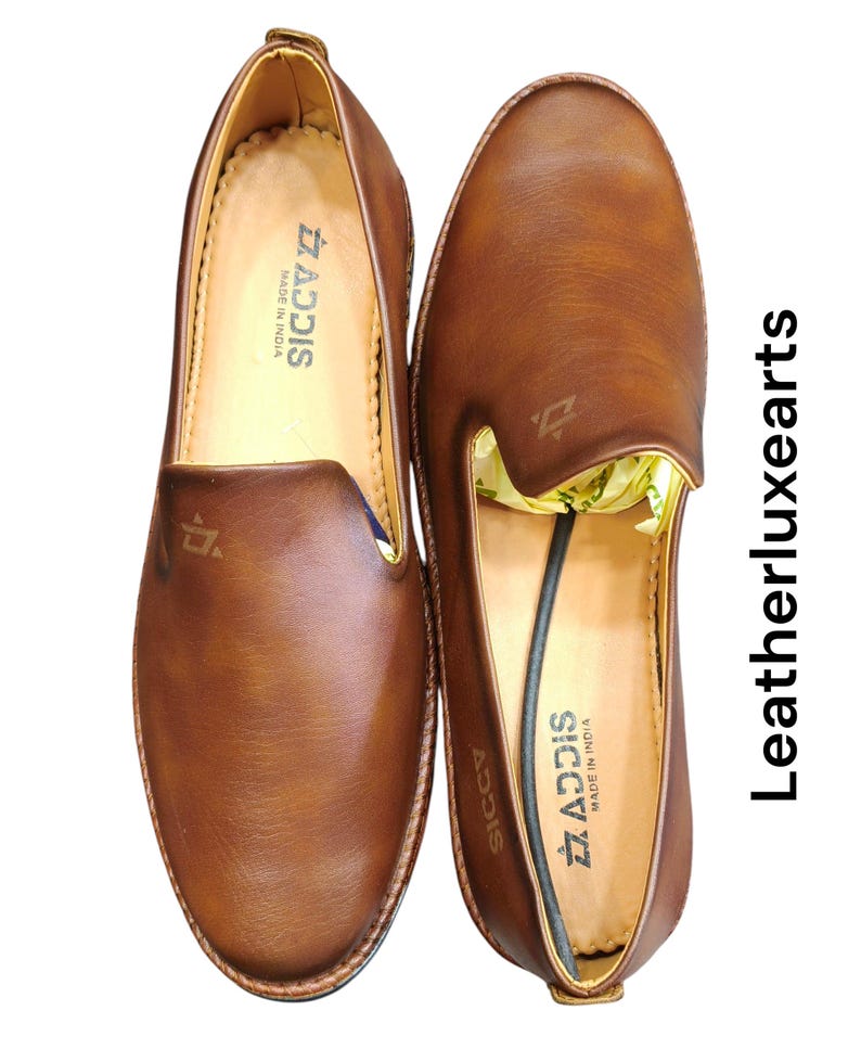 Pu&ograve; includere: Un paio di mocassini in pelle marrone. Le scarpe hanno un aspetto liscio e lucido con punta arrotondata e tacco basso. Il marchio "ADDIS" &egrave; visibile sulla soletta. "MADE IN INDIA".