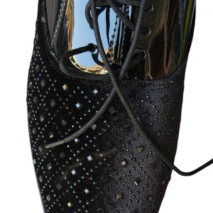 May include: Close-up of a black dress shoe with a velvet toe box embellished with square rhinestones. The upper portion is patent leather, and the shoe has black laces. The text "Leatherluxearts" is visible at the bottom.